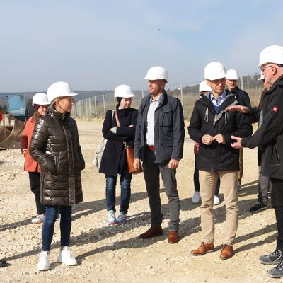 Helmut Göppel-Wentz, Leiter des Fachbereichs Liegenschaften und Technik beim Landratsamt Sigmaringen, führt Landrat Elmar Stegmann, die Kreisausschussmitglieder sowie die Beteiligten durch die Baustelle der Bertha-Benz-Schule in Sigmaringen