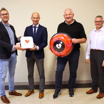 V.l.n.r: B&uuml;rgermeister Stefan Schneider, Landrat Elmar Stegmann, Martin H&ouml;bel (Vorsitzender des Sportvereins Oberreute) und Thomas Kaleja (Gesch&auml;ftsstellenleiter der Gesundheitsregionplus Landkreis Lindau) bei der &Uuml;bergabe des AED