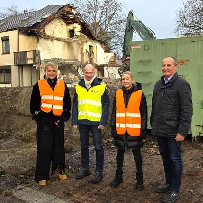 Tanja Frick, Landrat Elmar Stegmann und Sandra Pickenhahn vom Landratsamt Lindau sowie Jens Christiansen, stellvertretender Schulleiter des BSZ Lindau vor den Abbrucharbeiten der ehemaligen Hausmeisterhäuser auf dem BSZ-Gelände
